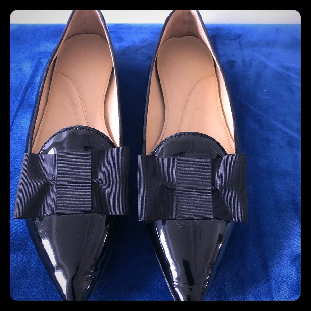 Patent leather ballet flat with bow accent.